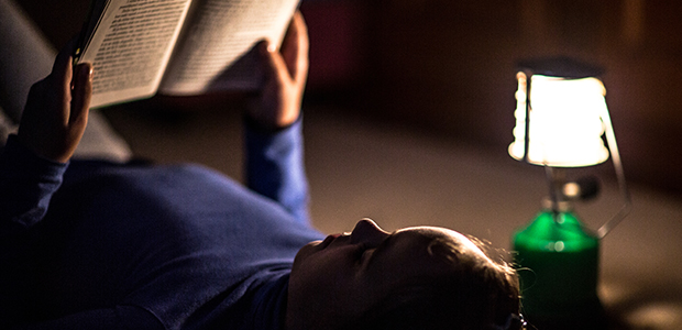 Girl reading book in lighting lamp