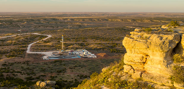 High cliff with drilling rig in background